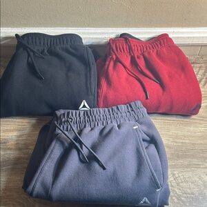 Three Reebok Men’s Joggers - Black, Red, and Gray Size Large.